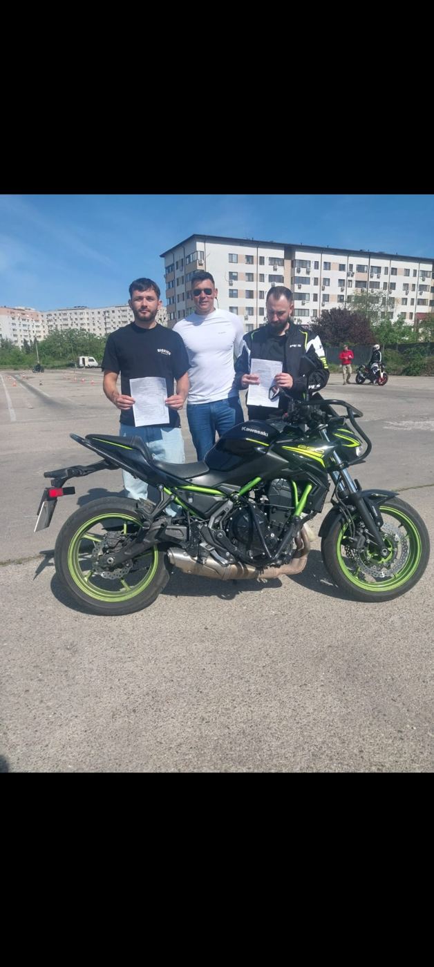 Absolvenți lângă motocicleta școlii